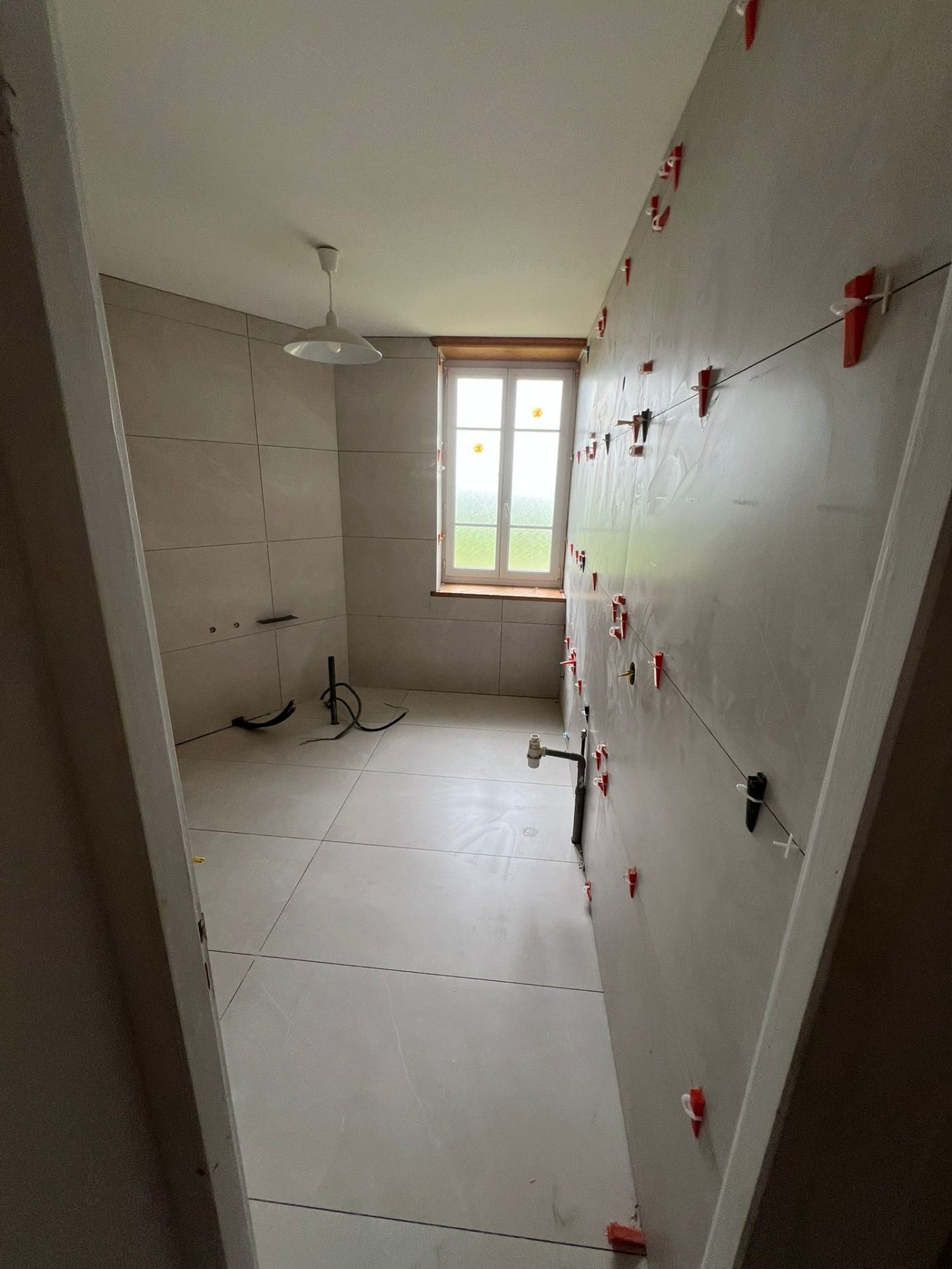 Pose de faïence murale en cours sur chantier rénovation salle de bain par NOVELON
